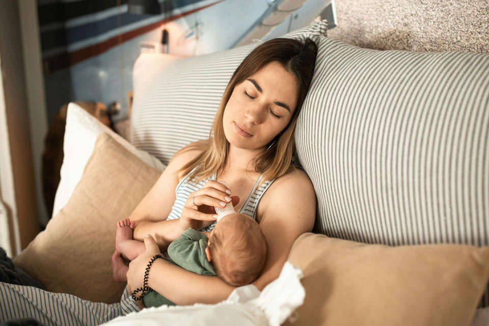 Picture of a young mother holding/feeding her newborn.