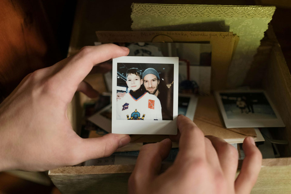 Pair of hands holding a polaroid, reminiscing about the past.